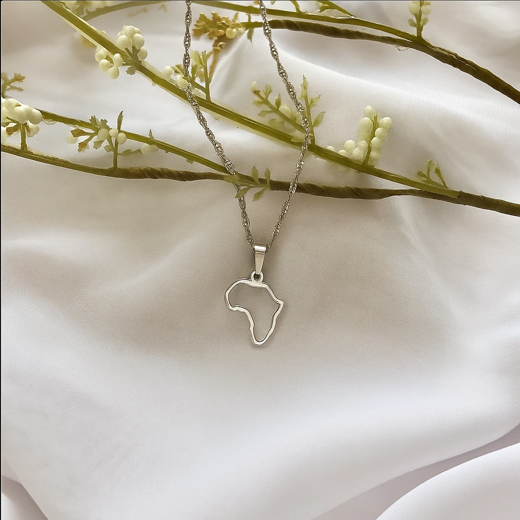 Silver necklace with an Africa outline pendant on a white fabric background
